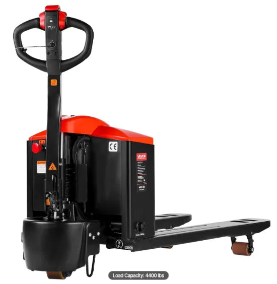 Walk-behind electric pallet jack transporting palletized products inside a busy distribution center.