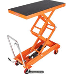 Hydraulic lift table cart transporting heavy industrial materials inside a warehouse facility.
